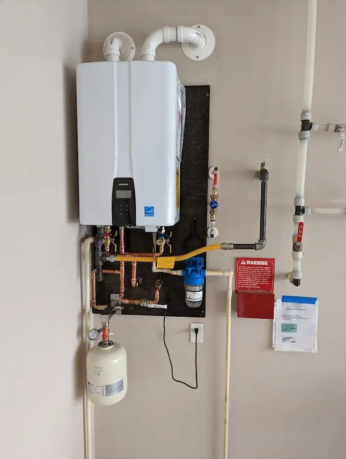 Professional plumber installing copper piping in a Collins home